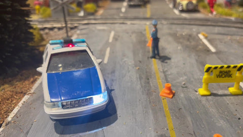 Police Car with LED Lights Near Railway Crossing