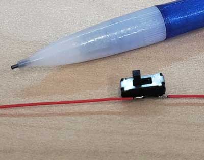 compact slide switch next to a pencil